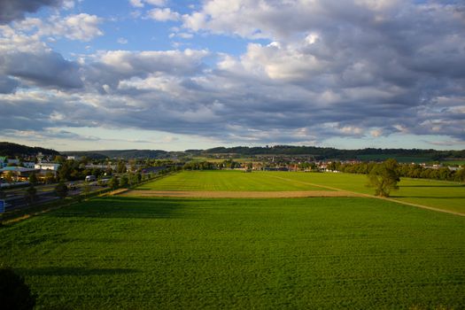 Big green field with blue sky. The view from the top