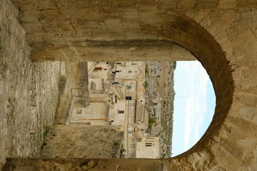 Matera, Basilicata, Italy. About 11/2019. Matera in Italy, world heritage of humanity. Door with arch and houses built in tufa stone of beige color.