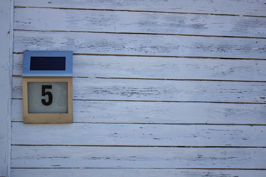 Plate with house number 5 on a white background.