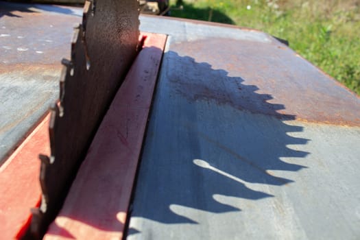 Round saw with teeth in the machine and its shadow.