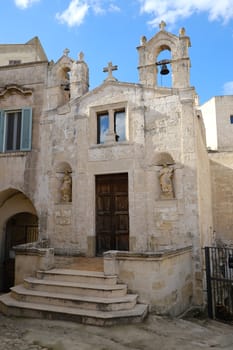 Church of San Biagio in Matera located in the Foggiali area. The construction is made of blocks of tufa stone of beige color. Facade with two small bells.
