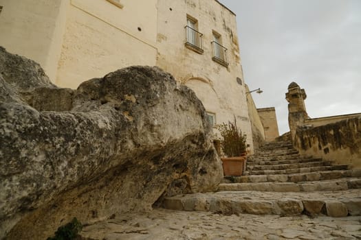 Matera, Basilicata, Italy. Houses, roads and alleys in the Sassi of Matera. Typical dwellings carved into the rock and with facades of beige tuff blocks.