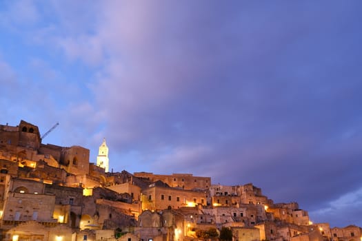 Night illumination of the ancient city of Matera. Houses made of blocks of tufa stone.