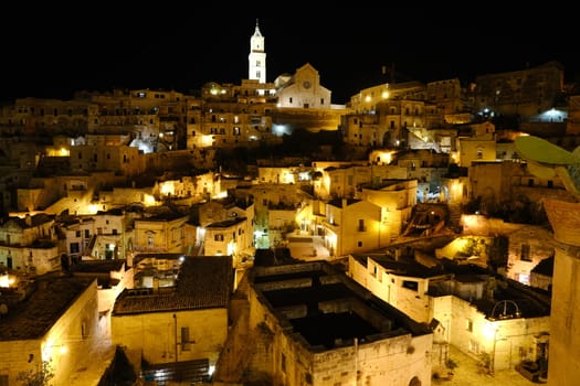 Night illumination of the ancient city of Matera. Houses made of blocks of tufa stone.