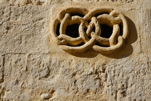 Matera, Italy. About 11/2019. Ventilation grid on the front of a house. Made of stone with a decorative shape.  Matera, Italy.