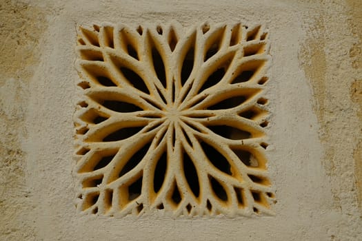 Matera, Italy. About 11/2019. Ventilation grid on the front of a house. Made of stone with a decorative shape.  Matera, Italy.