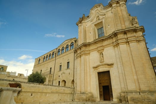 Church and Convent of Sant'Agostino in Matera. Courtyard with olive trees with leaves moving in the wind.
