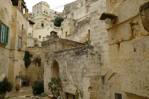 Courtyard with plant in a street of the ancient city of Matera. Houses in tufa stone.