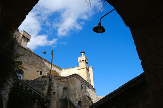 Chimney of an ancient Italian house in Matera. Above the old smokestack built with blocks of tuff stone, a fibrocemente (perhaps asbestos) fireplace has been installed.