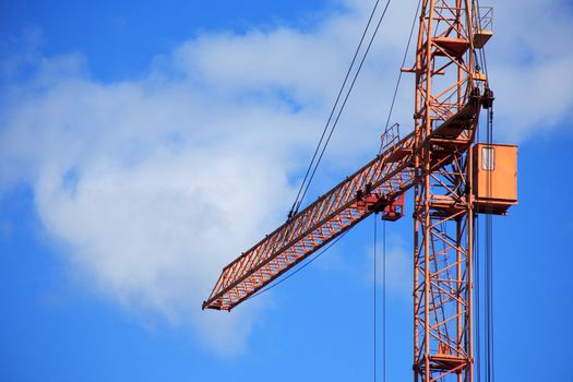 Industrial theme. Yellow construction crane against blue sky