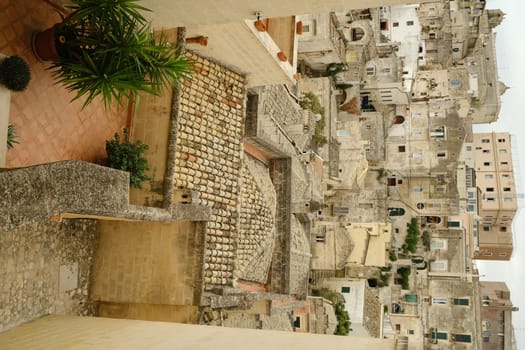 Streets, alleys and courtyards of the city of Matera. Typical houses built with blocks of tufa stone of beige color.