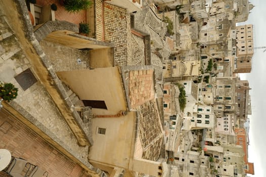 Matera, Basilicata, Italy. About 11/2019. Streets, alleys and courtyards of the city of Matera. Typical houses built with blocks of tufa stone of beige color.