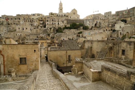 Matera, Basilicata.  Houses, roads and alleys in the Sassi of Matera. Typical dwellings carved into the rock and with facades of beige tuff blocks.