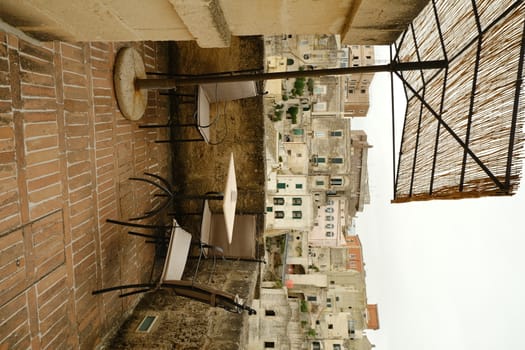 Chair with iron table in a courtyard in the city of Matera. Background with typical Mediterranean houses.