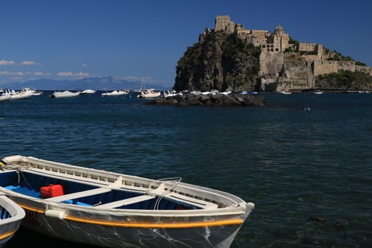 Ischia, Naples, Italy, About the July 2019.  Ancient Aragonese Castle in Ischia Ponte. The fortification stands on a peninsula of volcanic rock connected to the village of Ponte. Boats