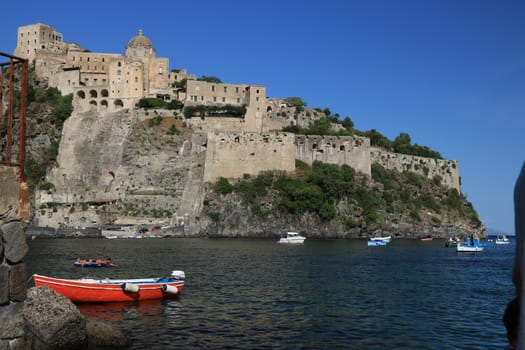 Ischia, Naples, Italy, About the July 2019.  Ancient Aragonese Castle in Ischia Ponte. The fortification stands on a peninsula of volcanic rock connected to the village of Ponte. Boats