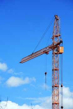 Industrial theme. Yellow construction crane against blue sky