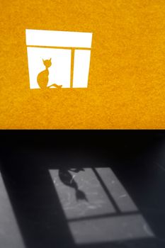 Composition cutting from yellow paper. Alone cat on the  window