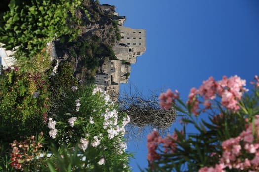 Ischia, Naples, Italy. Ancient Aragonese Castle in Ischia Ponte. The fortification stands on a peninsula of volcanic rock connected to the village of Ponte. Trees and flowers.