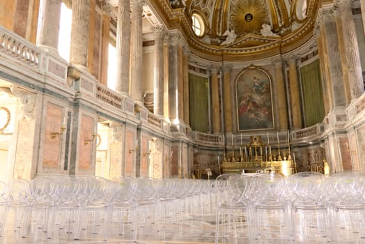 Interior of the chapel inside the palace. Contemporary plexiglass chairs.