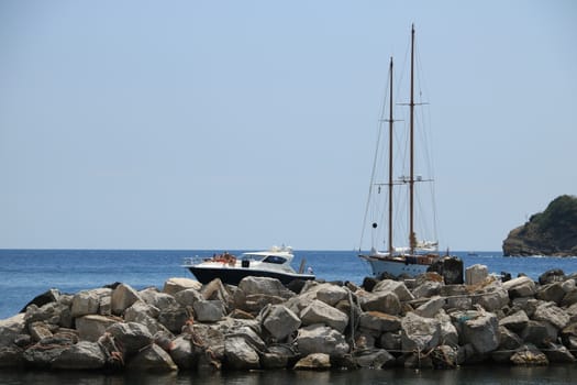 Procida island, Naples, Italy, About the July 2019. Boats moored outside the harbor dam. In the background the Mediterranean sea.