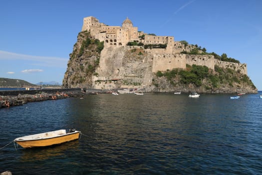 Ischia, Naples, Italy, About the July 2019.  Ancient Aragonese Castle in Ischia Ponte. The fortification stands on a peninsula of volcanic rock connected to the village of Ponte. Boats
