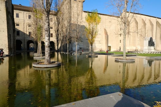 Buildings of the Pilotta in Parma. Fountain with pond and poplar trees. Emilia Romagna, Italy. 