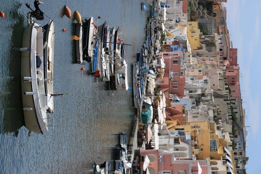 Procida island, Naples, Italy, About the July 2019. Boats anchored in the port of Corricella on the Island of Procida. Typical colorful Mediterranean style houses and fishing boats in the harbor.