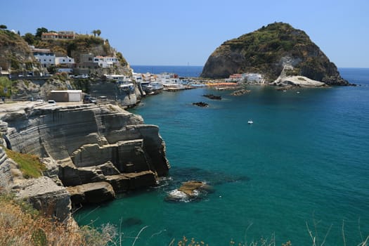 Sant'angelo di Ischia, Mediterranean sea near Naples. The mountain is connected to the mainland by a sandy beach with umbrellas.