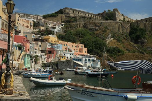 Procida island, Naples, Italy, About the July 2019. Boats anchored in the port of Corricella on the Island of Procida. Typical colorful Mediterranean style houses and fishing boats in the harbor.
