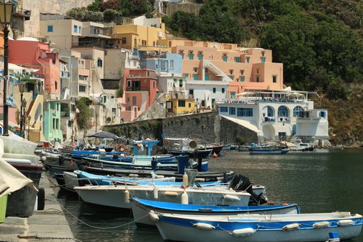 Procida island, Naples, Italy, About the July 2019. Boats anchored in the port of Corricella on the Island of Procida. Typical colorful Mediterranean style houses and fishing boats in the harbor.