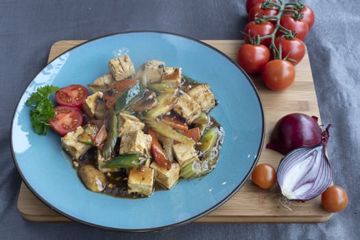 Stir fried toffu with vegetable served on blue plate