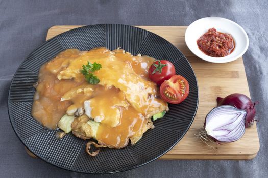 Omelet served with several type of vegetables and tomatoe sauce