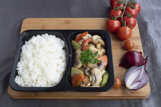 Stir fried chicken with white rice and vegetable served in a recipent for take away