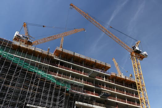 Scaffolding and cranes on a construction site. Cranes and scaffolding