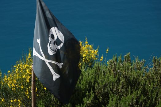 Cinque Terre, La Spezia, About may 2017. Pirate flag hoisted on the hills of the Cinque Terre in Liguria. In the background the sea.