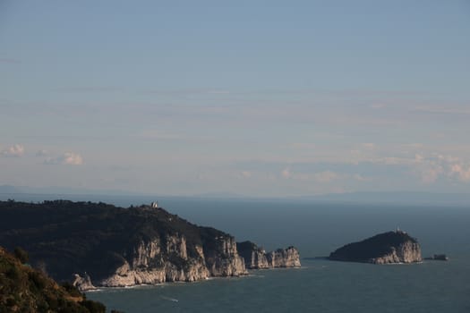 Reflections of light on the sea near the Cinque Terre in Liguria. Palmaria island with mountain and trees in the foreground.