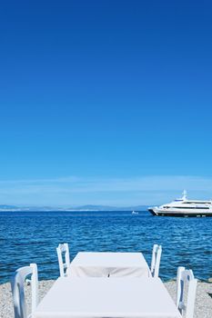 Empty restaurant by the Aegean sea and cruise boat, travel and nature, scene