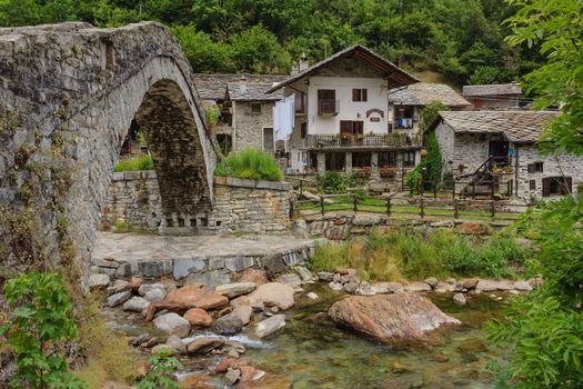 the bridge leads to the characteristic alpine village of Fondo,made of stone houses with the stone  roofs