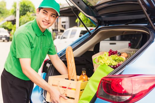 Asian delivery man grocery prepare service giving fresh vegetables food and fruit full in wooden basket on back car to send woman customer at door home after pandemic coronavirus, Back to new normal