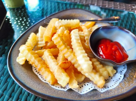 Golden French fries potatoes on dish ready to be eaten  with tomato sauce