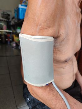 close-up asian old man measuring hypertension blood pressure on his arm