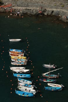 Vernazza, La Spezia, Italy About 9/2018.Typical colored fishing boats, Gozzo type, anchored in the harbor of Vernazza in the Cinque Terre. Top view of the path.