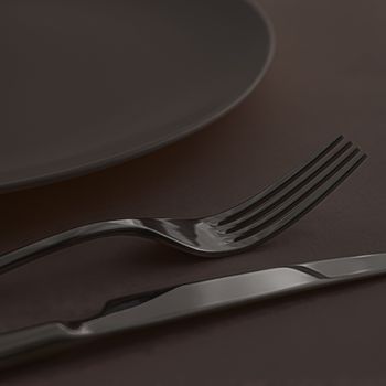 Empty plate and cutlery as mockup set on dark brown background, top tableware for chef table decor and menu branding design