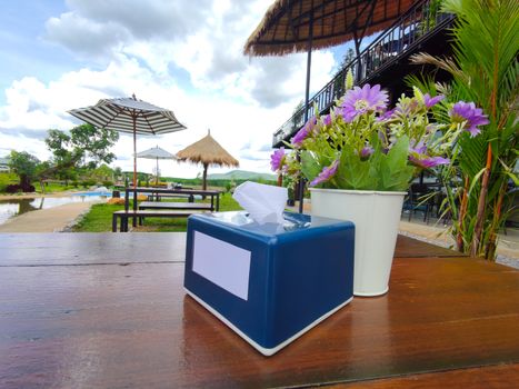 blue tissue box on wood table in outdoor restaurant