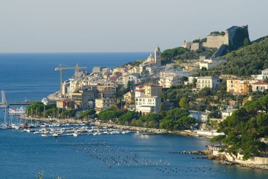 Panorama from the top of Portovenere, near the Cinque Terre, at sunrise light. The bay with the marina, the fort, the church of San Pietro. La Spezia