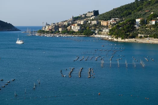 Portovenere, Liguria, Italy. About 10/ 2019. Panorama from the top of Portovenere, near the Cinque Terre at sunrise light. The bay with the mussel farm, the fort, the church of San Pietro.