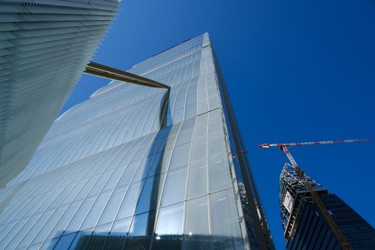 Milan Citylife, Lombardia, Italy. About 10/2019. Detail of the facade of the Allianz skyscraper by Arata Isozaki. in Milan. Contemporary architecture in the complex of the three towers at Citylife. In the background  Libeskind towe under construction.