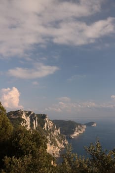 Mountains overlooking the sea near the Cinque Terre. In the background the church of Portovenere and the islands of Palmaria and Tino. Photo at sunset.