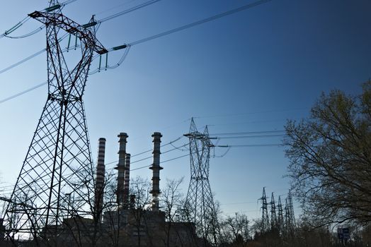 The Turbigo power plant, 40 km from Milan, owned by Iren is located along the Naviglio Grande. The video shows steam puffs coming out of the central, behind the tall chimneys.  The shot goes from the chimneys and pylons to the view of the dry river bed of the Naviglio that flows nearby.